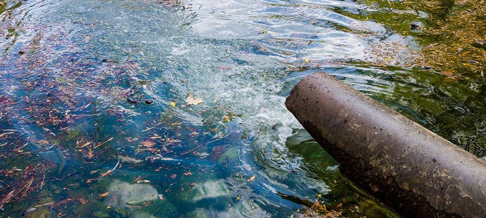 water spilling into pond from pipe