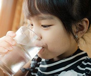 A child drinking a glass of water